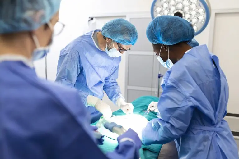 dokter mengelilingi meja operasi - apa itu lumpektomi?
